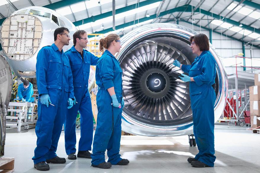 Aerospace engineering technology team inspects a large jet engine in an aircraft maintenance facility.