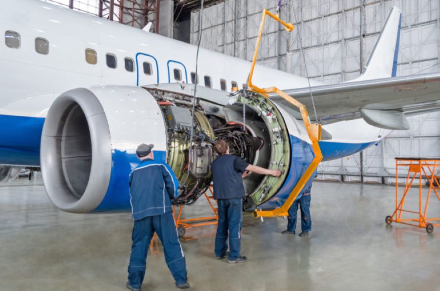 Engineers perform jet engine maintenance